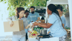Snap Benefits Will Be Disrupted by the Government Shutdown. Photo show volunteers assisting a woman waiting in a food distribution line.