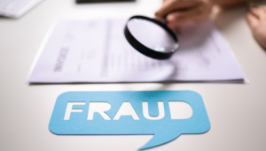 Understanding and Preventing Fraud on property. Fraud displayed in foreground and magnifying glass searches over a blurred income document.