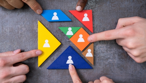a group of people holding colorful triangles with people on them. The triangles fit together to make a square, organizational readiness for affordable housing