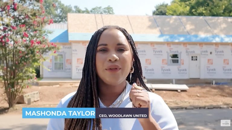 Woodlawn CEO in front of one of the four homes